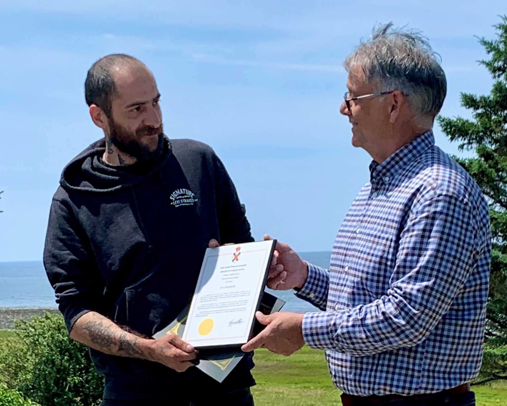 Two people presenting a certificate